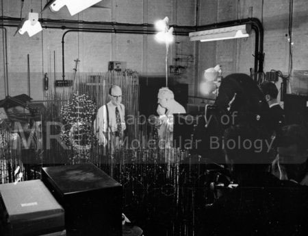 Max Perutz in the model room at the Cavendish Laboratory c. 1960. [The remains of the original DNA model can be seen in the right-hand corner at the back. Other models include the newer ball and spoke DNA model, and probably 'rod' models of myoglobin and haemoglobin.] The cameras are set up to film the BBC programme 'Eye on Research: Shapes of Life' (1960).