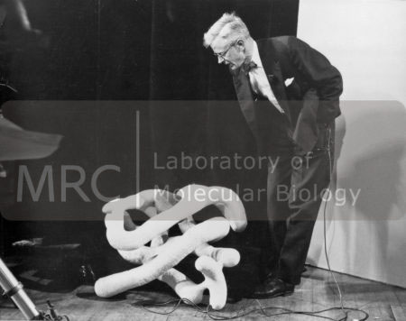 John Kendrew lecturing, with 'sausage' model of myoglobin, c. 1960s.
