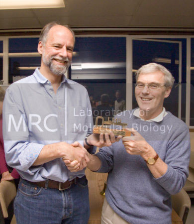 Richard Henderson (right) handing over the 'key to the LMB' to Hugh Pelham (left), when Hugh took over from Richard as Director of LMB . Taken in the LMB canteen on 10 November 2006.