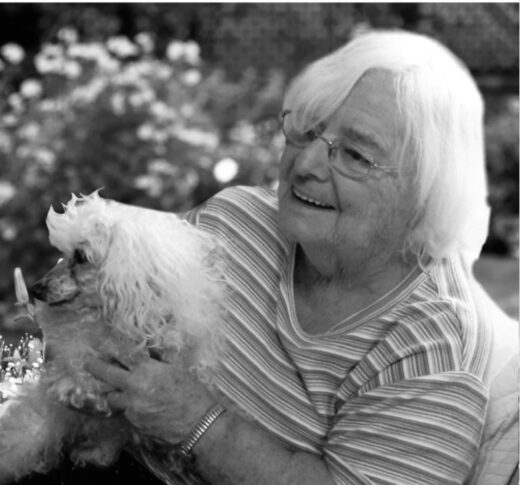 Black and white photo of Muriel Wigby holding a dog