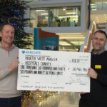 LMB Director Jan Löwe presents a large check to Phillip Fearn, of the North West Hospitals Charity.