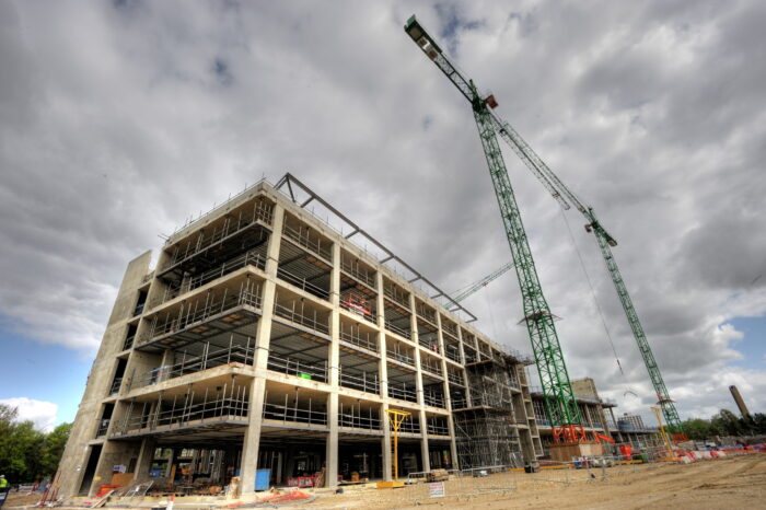 The LMB building in 2010, part of a building site surrounded by scaffolding and two large, green cranes
