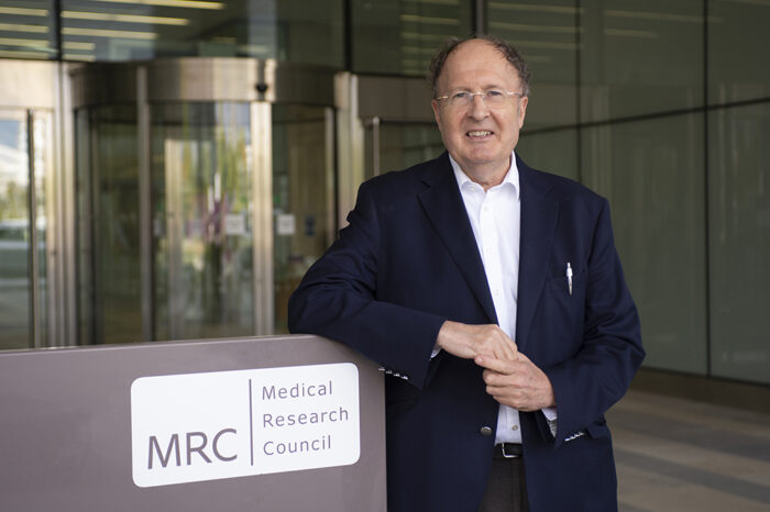 Photo of Greg Winter standing next to MRC LMB sign outside LMB building