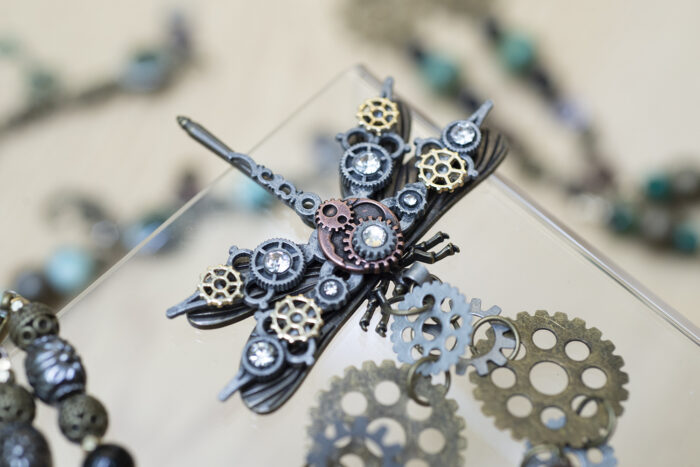 Jewellery resembling a dragonfly, created with cogs in various colours of metal.