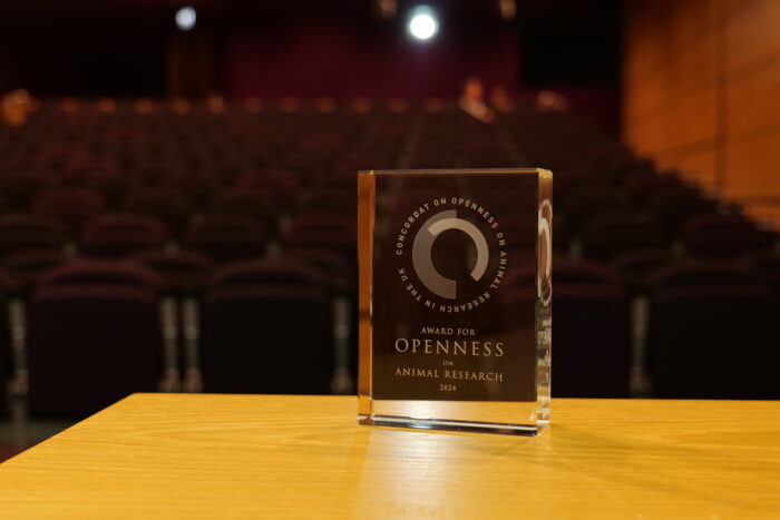 The Award for Openness on Animal Research 2024, a glass trophy, sat on a wooden table in a lecture theatre.