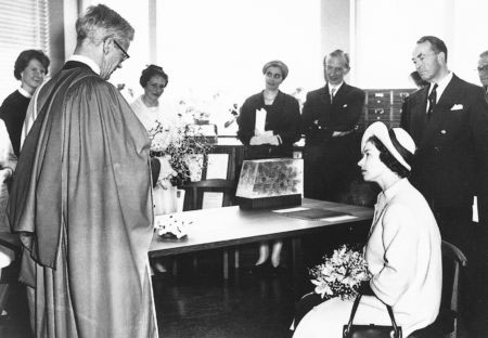 The Queen being shown an exhibition of scientific models during her visit to open the building. From left to right: Mavis Blow, John Kendrew, Gisela Perutz, Charlotte Himsworth, Harold Himsworth, The Queen, Lord Shawcross